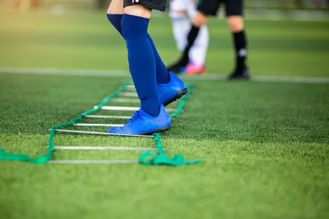 Kid soccer player Jogging between marker for football training. Stock Photos