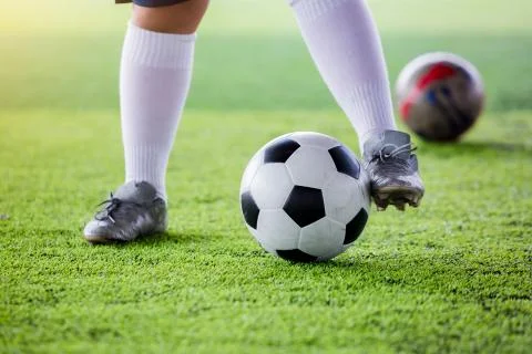 Kid soccer player jogging with control ball to shoot to goal on artificial tu 스톡 사진