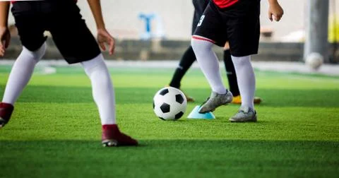 Kid soccer player put white sport shoes jogging and control ball go to other  Stockfoto's