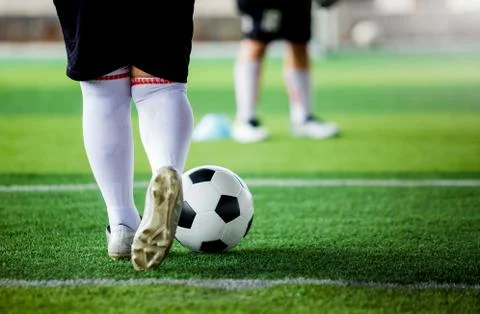 Kid soccer player put white sport shoes jogging and control ball go to other  Stock Photos