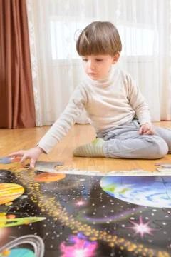 Kid Solving a Floor Puzzle Stock Photos