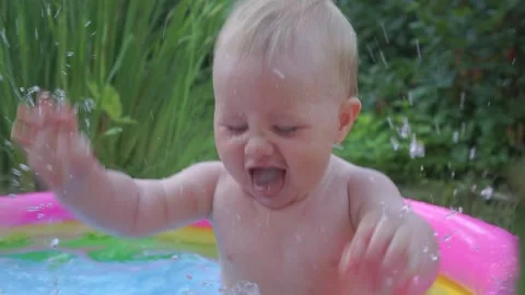 Kid splashing in the pool having fun Vídeos de archivo 157399714