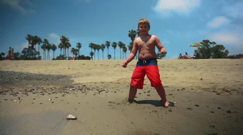 Kid standing in front of ocean at beautiful beach, shot in slow motion Stock Footage 63882686
