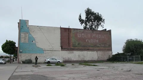 Kid standing in front of old building with single car Stock Footage 155491705