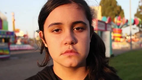 Kid stares blankly into camera at a deserted carnival Stock Footage 154941298