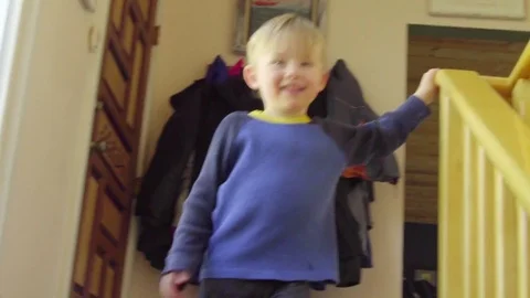 Kid steps down the stairs, smiling Stock Footage 76283890