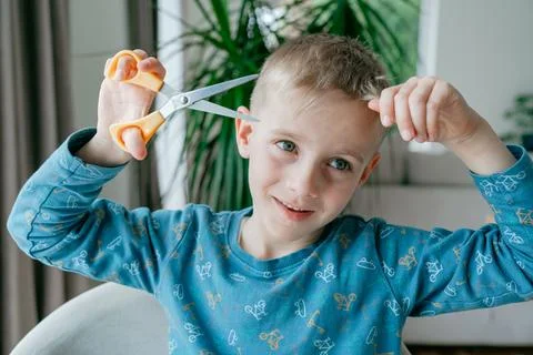 Kid stretching scissors play Stockfoto's
