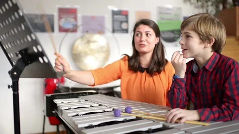 Kid studying percussion instrument vibraphone, teacher next to him Video stock 72953189
