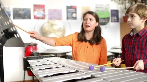 Kid studying percussion instrument vibraphone, teacher next to him Video stock 91757278