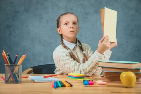 Kid with surprised face expression and stylish outfit read book and found it Stock Photos