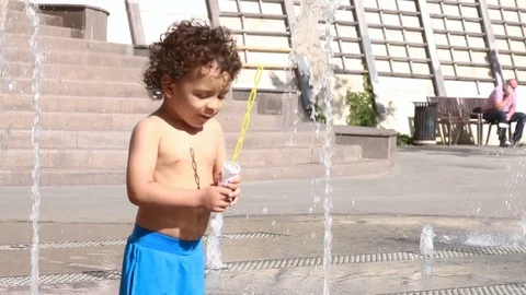 Kid trying to blow soap bubbles	 Video stock 124008786