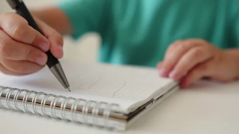 Kid trying to learn handwriting. Close up shot of a child's hands holding a.. Stock-Footage 340724942