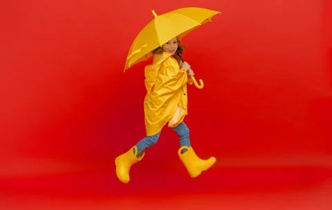 Kid with umbrella on colored background. Stock Photos