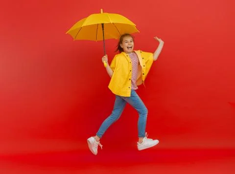 Kid with umbrella on colored background. Stock-Fotos