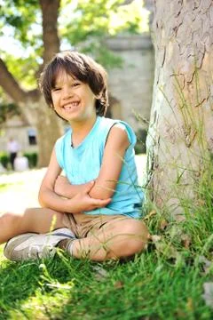 Kid under the tree in park Stock Photos