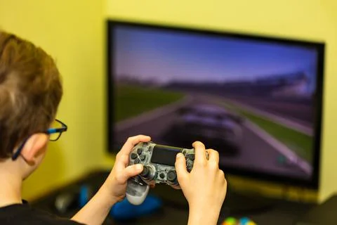 Kid using controller to play video game. Stock Photos