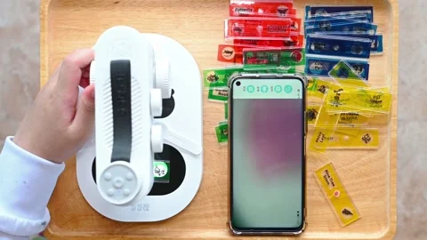 Kid using an electrical microscope and seeing the enlarge photo on a mobile Stock Footage 176781845