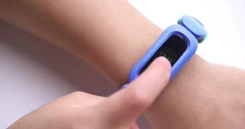 A kid using a Fitbit Ace 3 with a cosmic blue and astro green classic wristband Stock Footage 170677170