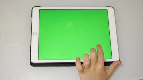 Kid using hand gestures on iPad app with green screen Stock Footage 129354391
