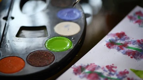 Kid using paintbrush to mix green color for painting Stock Footage 121211253