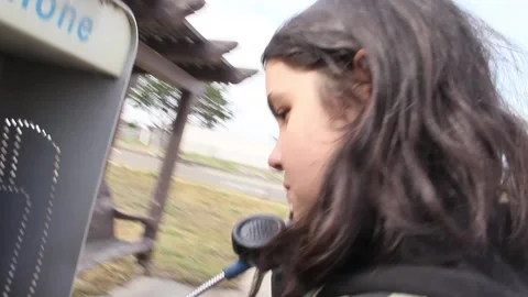 Kid using pay phone Stock Footage 155385993