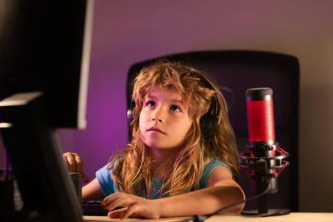 Kid using pc at night. Child with computer in a dark room. School, study, online 写真素材