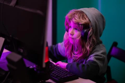 Kid using pc at night. Child with computer in a dark room. Little hacker, young Stock Photos