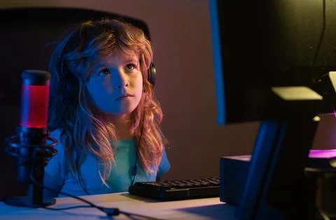 Kid using pc at night. Child with computer in a dark room. Social network for 写真素材