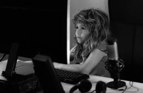 Kid using pc at night. Child with computer in a dark room. Stock Photos