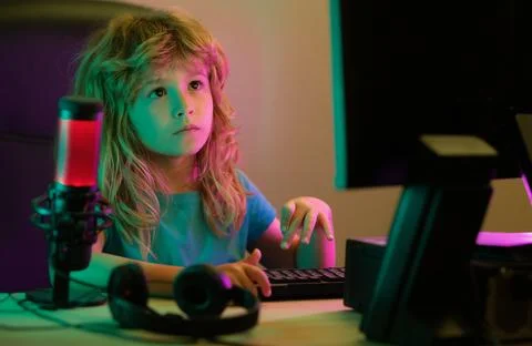 Kid using pc at night. A pretty child learns a lesson using a desktop computer Stock Photos