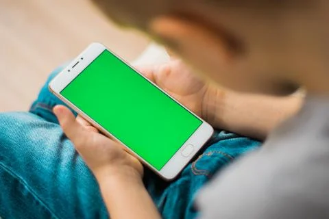 Kid using smartphone during a sunny day at park 스톡 사진