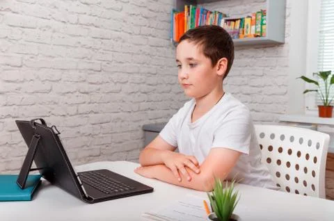 Kid using tablet learning at home. Home schooling, distance learning Stock Photos