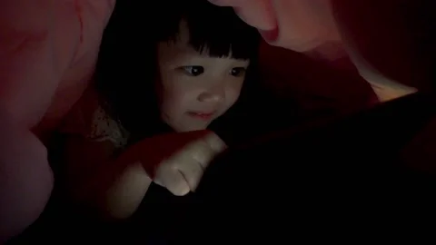 Kid using tablet pc under blanket at night Stock Footage 131874163