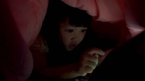 Kid using tablet pc under blanket at night Stock Footage 131874207