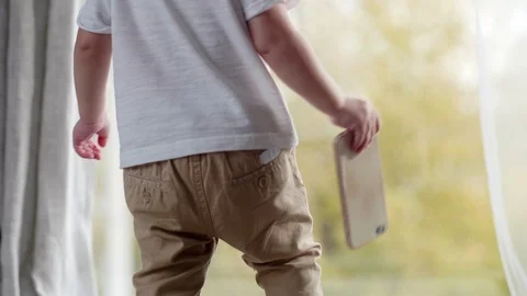 Kid Walking on Bed with Smartphone Stockbeeldmateriaal 101041312