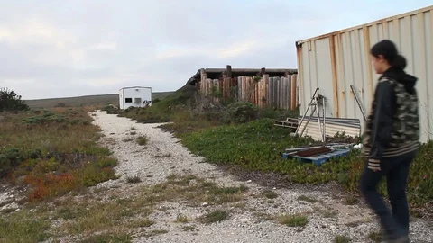 Kid walking down dirt road in middle of nowhere town Stock Footage 114214810