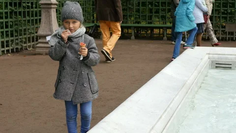 Kid walking in park. child throws a coin into the fountain and makes a wishes Stock Footage 103805413
