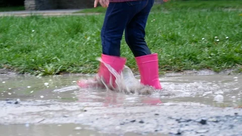 Kid walking through puddle Stock Footage 106146595