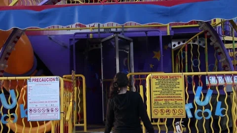 Kid walks up to empty ride at deserted fair Stock Footage 154941491
