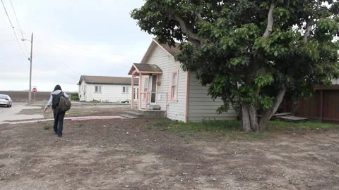 Kid walks past empty dirt property Stock Footage 155489184
