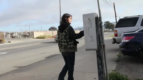 Kid walks up to pay phone from bus stop Stock Footage 155385507