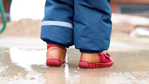 The kid walks through a puddle. Stock Footage 171623608