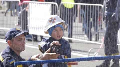 Kid wander reaction using fire hose at firefighter festival in Kyiv Stockbeeldmateriaal 116381452
