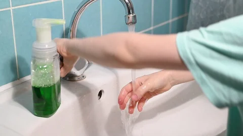 Kid washes hands using antibacterial liquid soap in bathroom Stock Footage 127876798