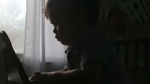 Kid watches tablet as mom opens curtains, video Stock-Footage 79720186