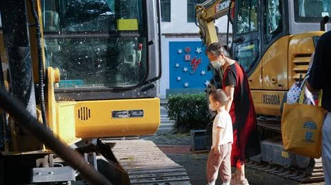 Kid watching construction work, machinery, bulldozer, excavation,Shanghai, China Stock Photos