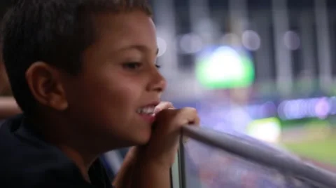 Kid watching a game from the stands at a stadium Stock Footage