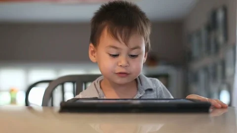 Kid watching tablet and talking at it, video Видео 80351755