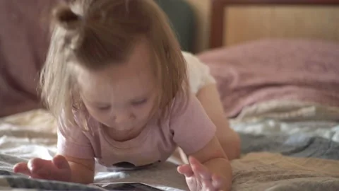 Kid watching video on smartphone, lying on his stomach Stock Footage 147173587