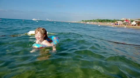 Kid in the waves on the sea beach Stock Footage 12495433